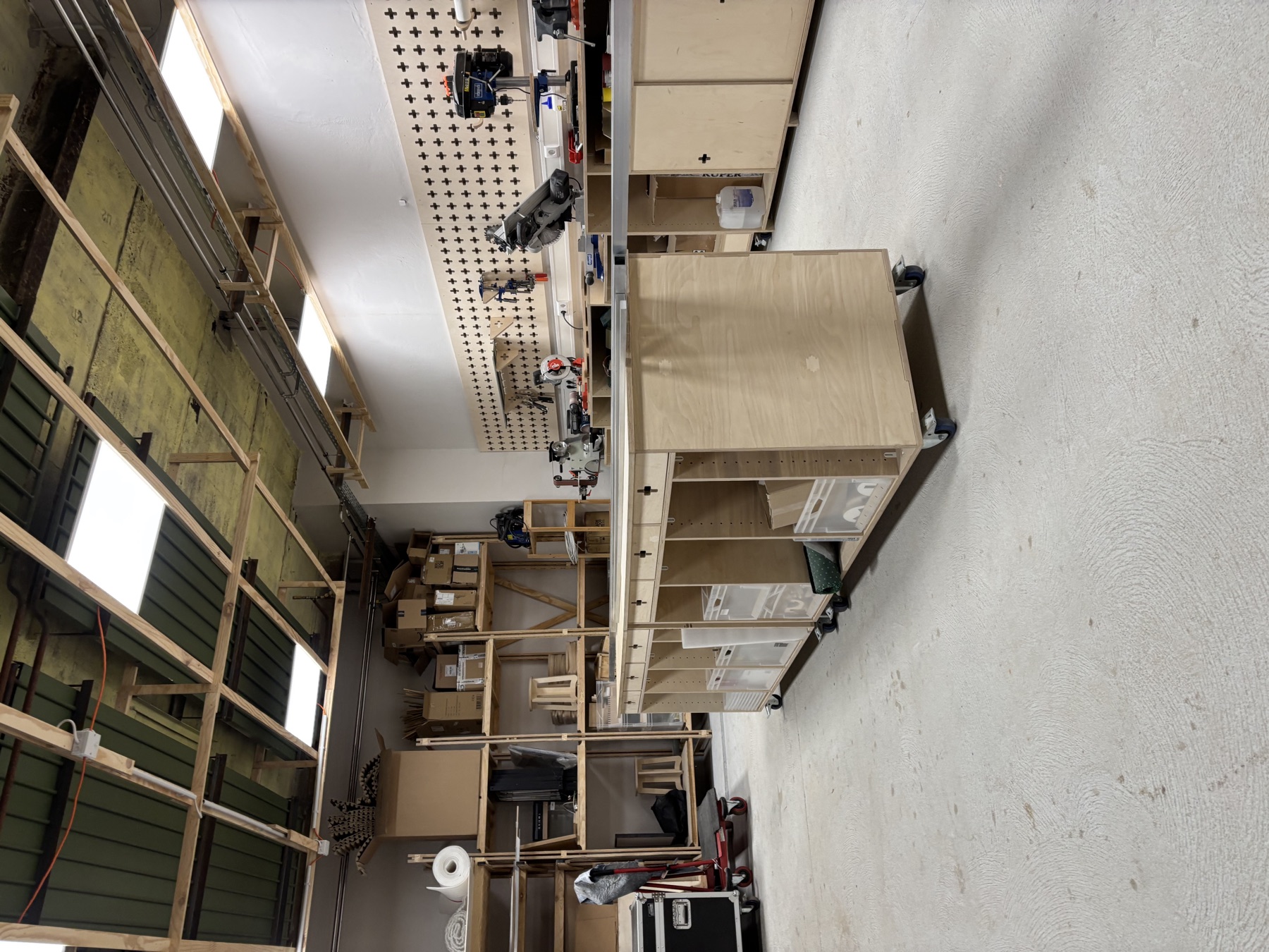 Werkstatthalle des vectorlab mit rollbarer Werkbank, Regalen und Lochwand